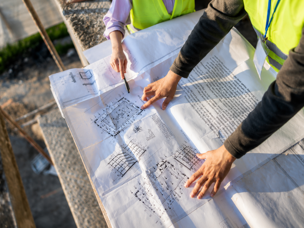 A roofing contractor reviewing building plans representing the permit application process required by Lexington-Fayette Urban County Government before any roofing replacement begins
